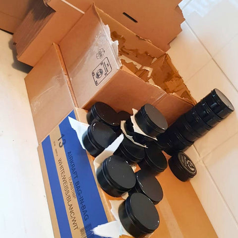 Eerste levering van Phoenix Pomade potjes in dozen, handmatig verpakt en klaar voor verzending.